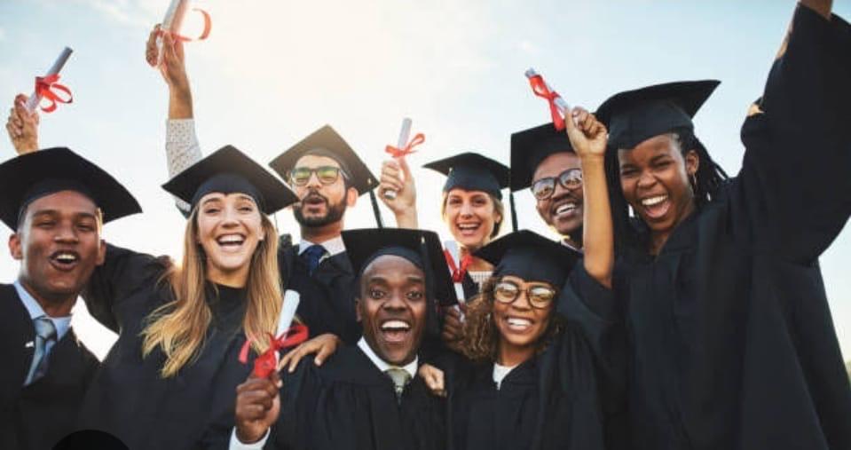 Group of international graduates cheering in caps and gowns